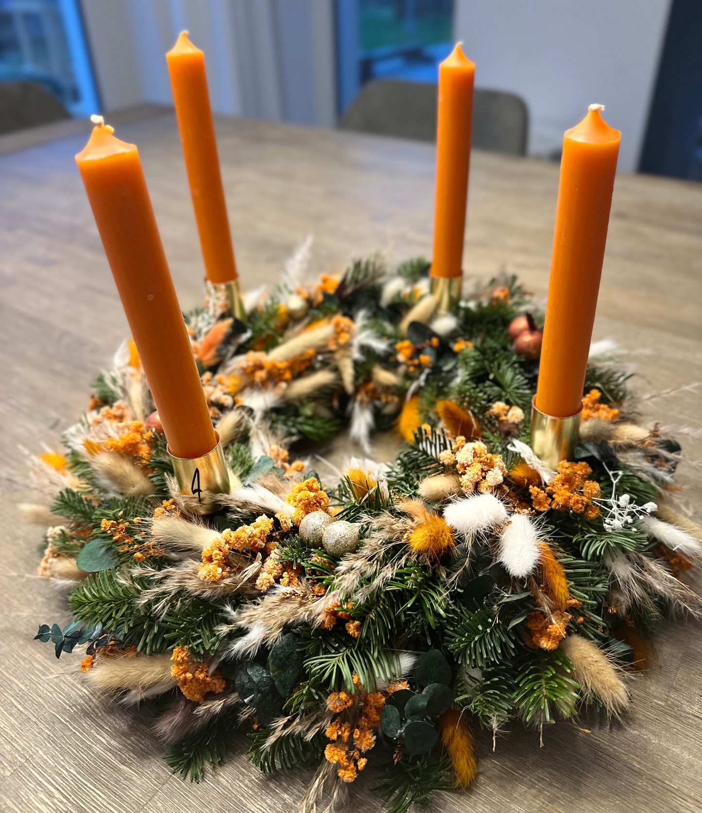 Adventskranz mit Trockenblumen und Gräsern - ein Kontrast in Orange